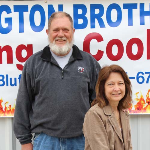 Stan and Mary Buffington, second-generation owners, in front of the Buffington Brothers company sign.