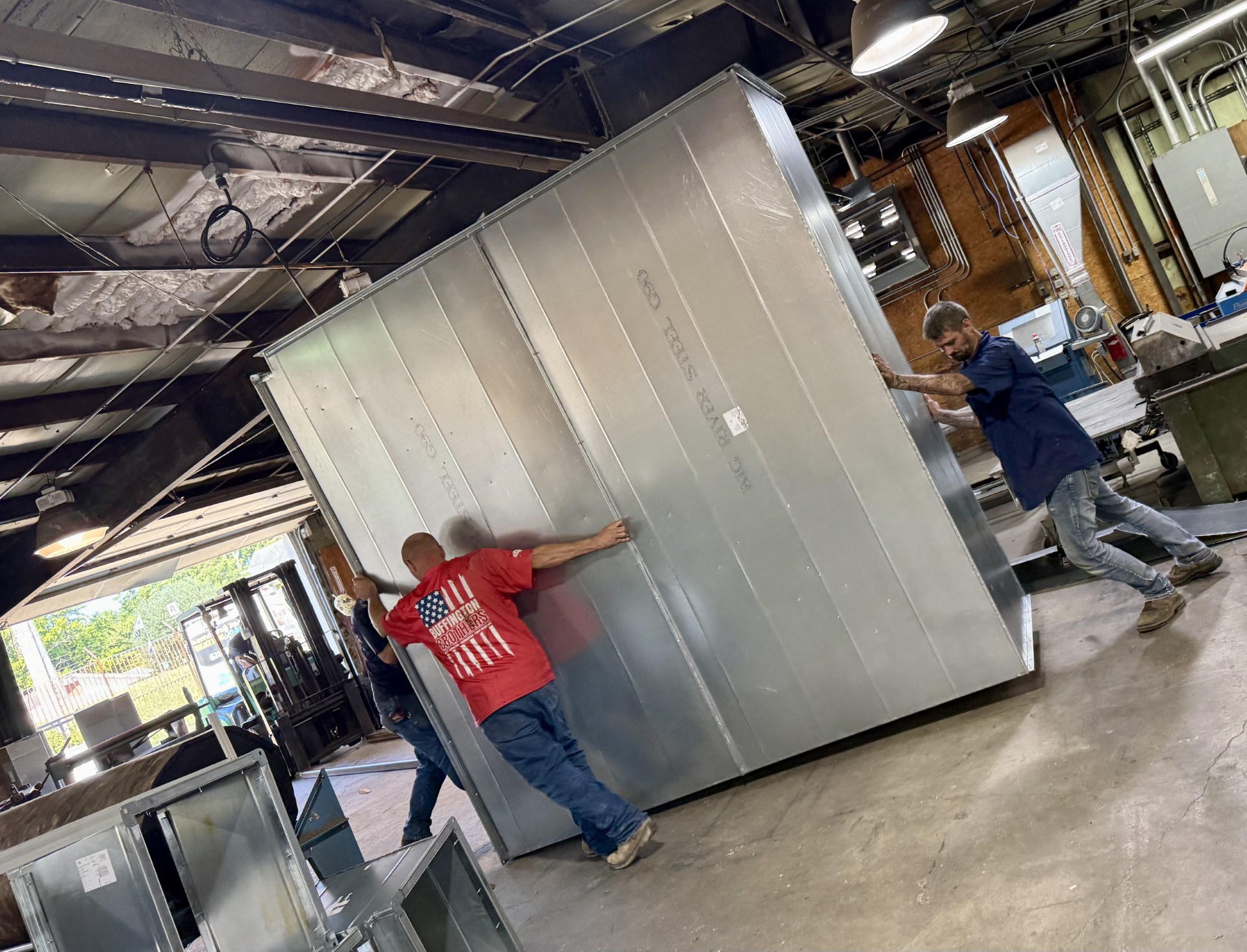 Buffington Brothers crew moving a large custom-fabricated plenum through the shop for a commercial project.